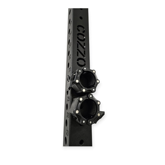 Dettaglio collari magnetici Cozzo Strength agganciati al telaio del rack, sistema salvaspazio per tenere i fermadischi sempre a portata di mano e l'area di allenamento ordinata